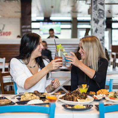 Table full of food and 2 clients smiling