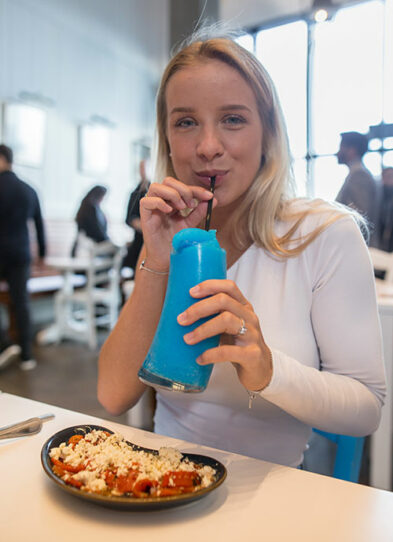 Blonde girl drinks a blue drink
