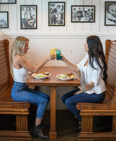 Two girls cheering up their Souvlaki Bar drinks