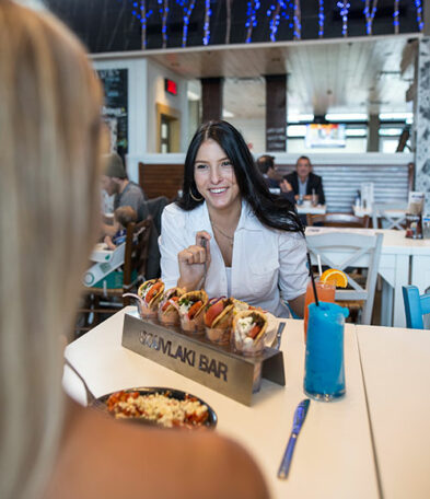 brunette girl with souvlakis on the table