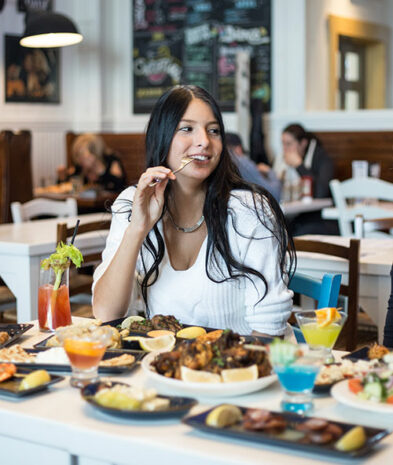 Girl bitting her fork as she is about to eat